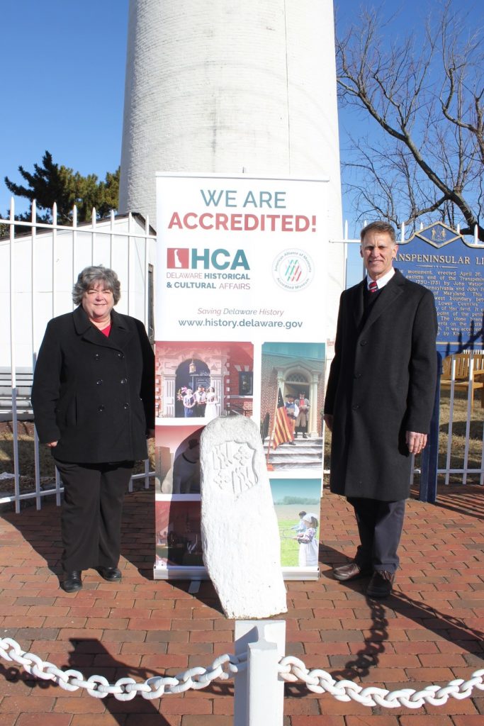 State Rep. Ronald Gray visits the Fenwick Island Lighthouse in celebration of the Division of Historical and Cultural Affairs’ accreditation by the American Alliance of Museums. At left is division Deputy Director Suzanne Savery. In front of Savery and Gray is the Transpeninsular Line marker which indicates the boundary between Delaware and Maryland.