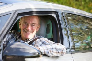 Image of a happy senior driving a car