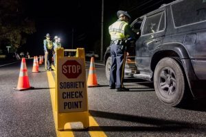 police officer and suv on road at nighttime with yellow caution sign on street