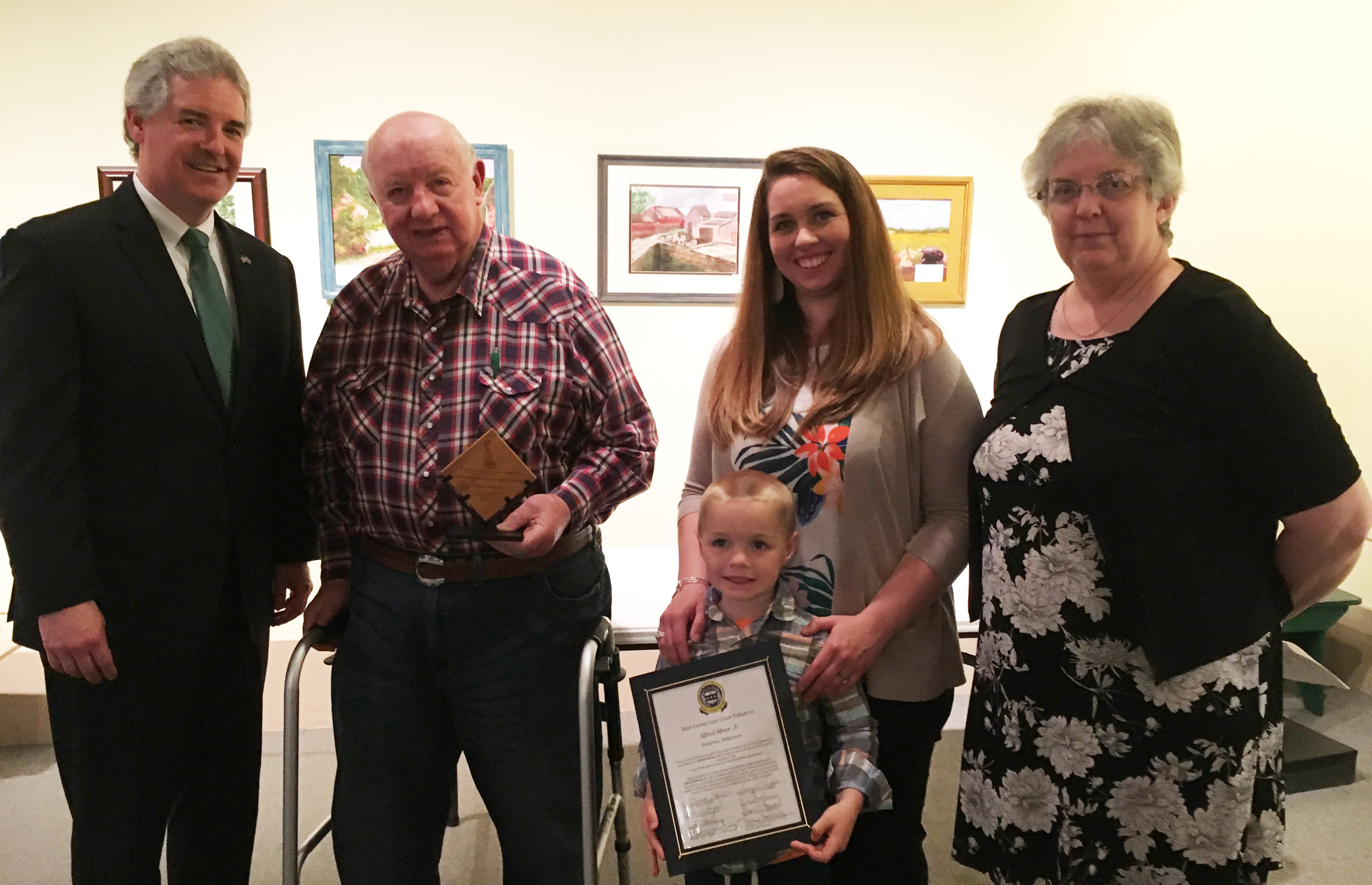 DNREC Secretary Shawn M. Garvin congratulates Kent County Agricultural Award honoree Alfred Moor Jr. of Smyrna, with his granddaughter-in-law Hallie Moor, great-grandson Everett Moor, and Gail Montgomery.