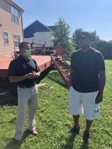 Insurance Commissioner Trinidad Navarro speaking to a resident whose deck was damaged by the storm.