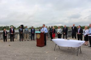 Governor Carney stands behind a podium at a bill signing ceremony event located at a solar array in Wilmington.