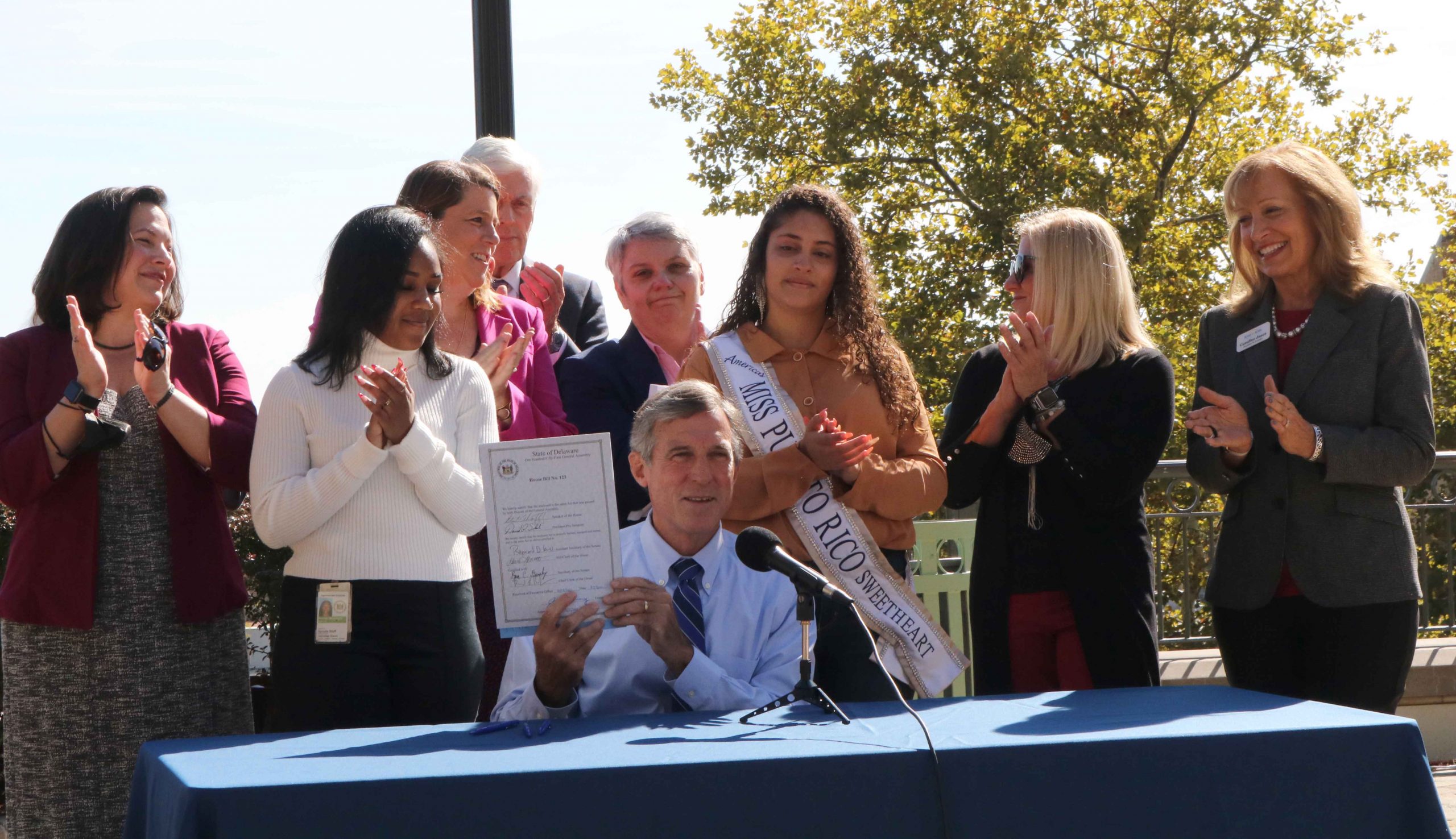 Governor Carney holds up House Bill 123 after signing it into law.