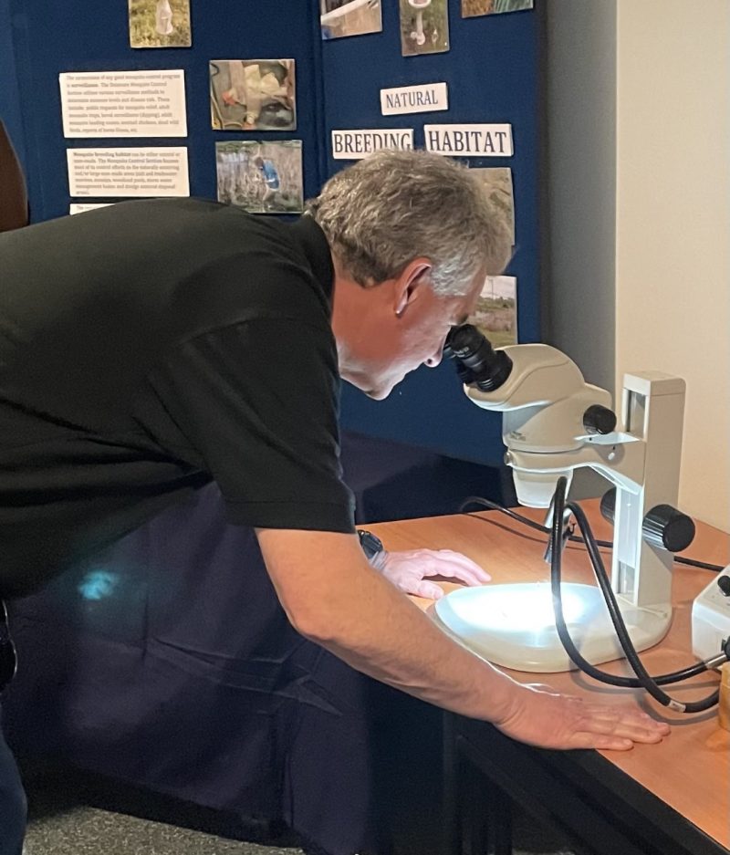 DNREC Secretary Shawn M. Garvin takes an up close look at a mosquito under the microscope.