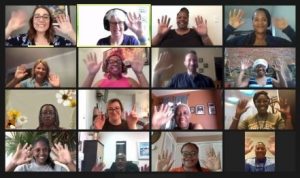 Families and educators on zoom smiling and waving to the camera.