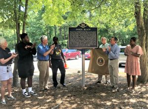 Gov. John Carney and DNREC Secretary Shawn M. Garvin unveiled a Division of Public Archives historical marker to dedicate Jason Beach as a historic site in recognition of its significance and to coincide with the Juneteenth holiday. Pictured, from left to right, are Rep. Ruth Briggs-King, MERIT Student Speaker Jaden Burton, Secretary Garvin, town of Laurel Councilmember Jonathan Kellam, Rep. Timothy Dukes, Gov. Carney and MERIT Student Speaker Kianna Kelley.