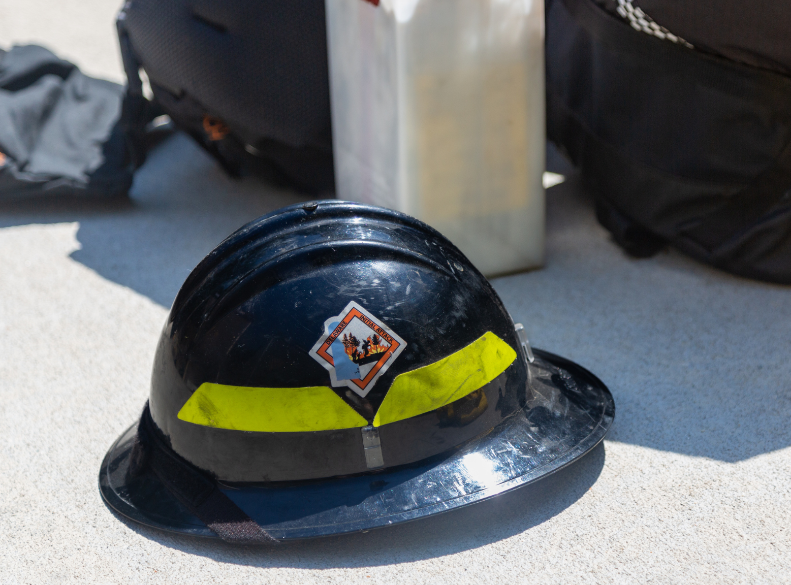 Delaware's black wildland firefighter helmet with yellow tape and wildfire logo