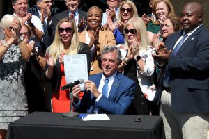 Governor Carney holding HB 205 after signing