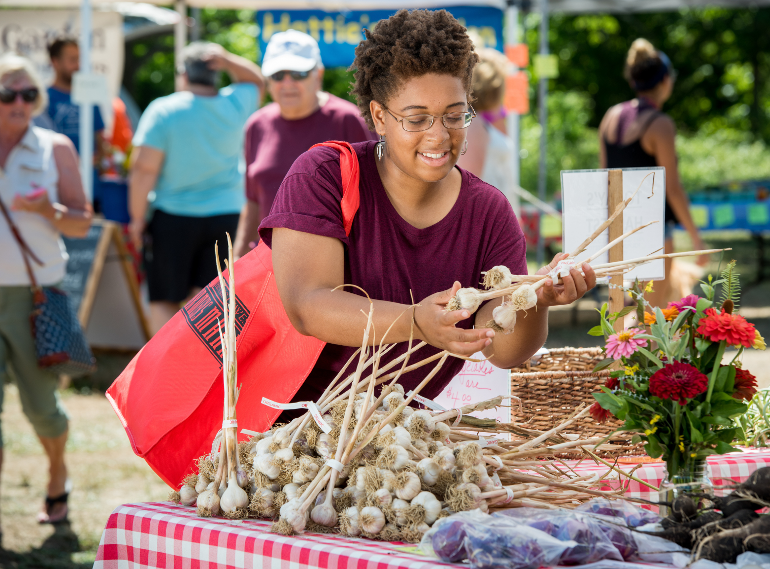 Woman selecting garlic bulbs at a Delaware farmers market