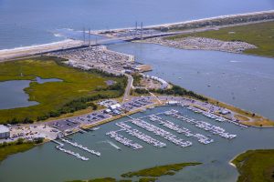 The Indian River Marina sits along the Indian River Inlet with its more than 150 boat slips in the foreground, buidings in the center and iconic inlet bridge toward the top of the photo, all surrounded by water from the Atlantic Ocean and inland bays.