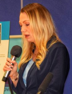 Woman speaking into microphone.
