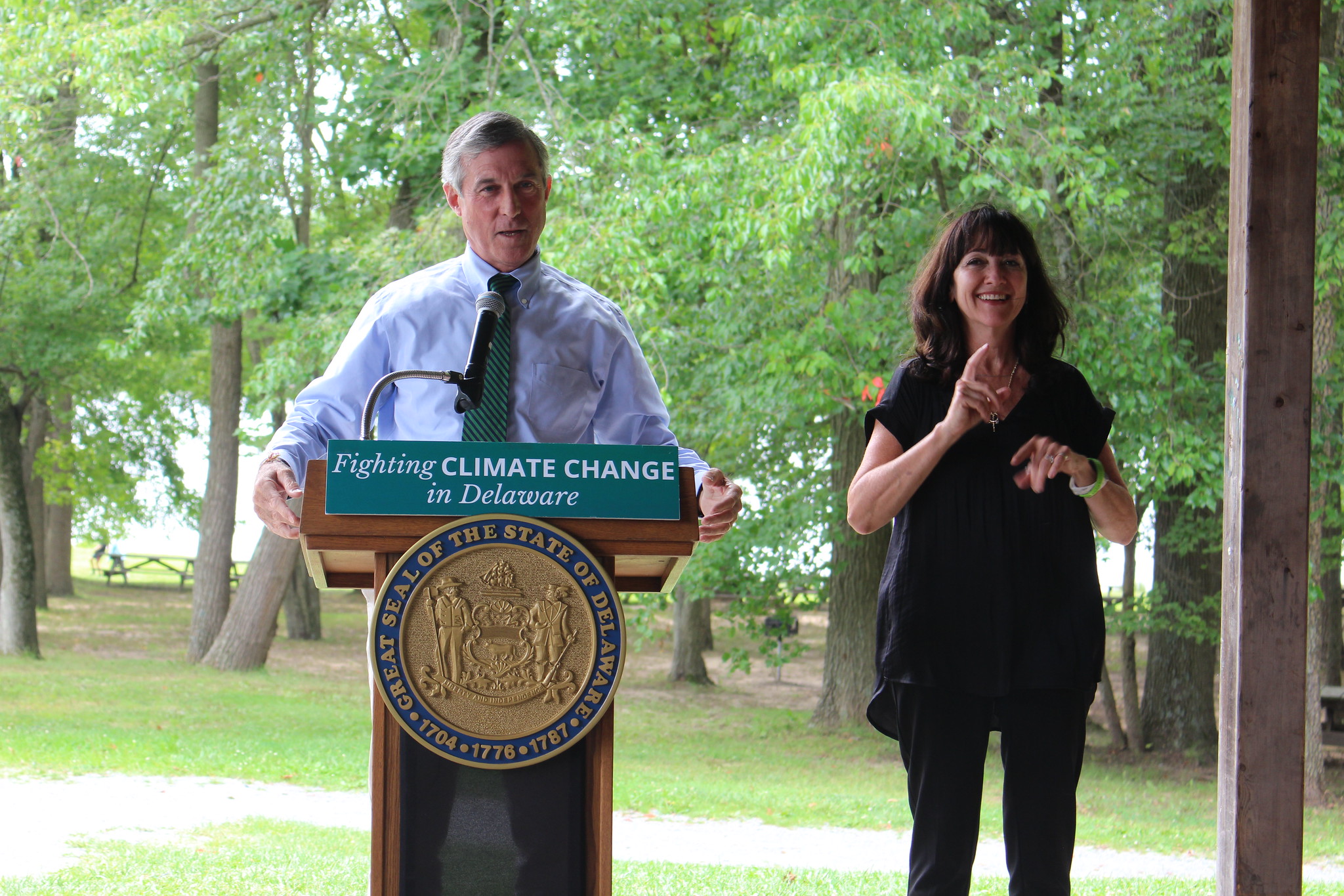 Image of Governor Carney and interpreter Pamela in front of woods during an environmental press briefing.