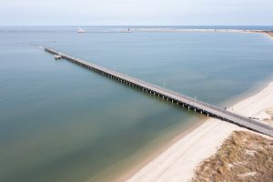 A fishing pier juts out from the Cape Henlopen State Park Beach into the Atlantic Ocean.
