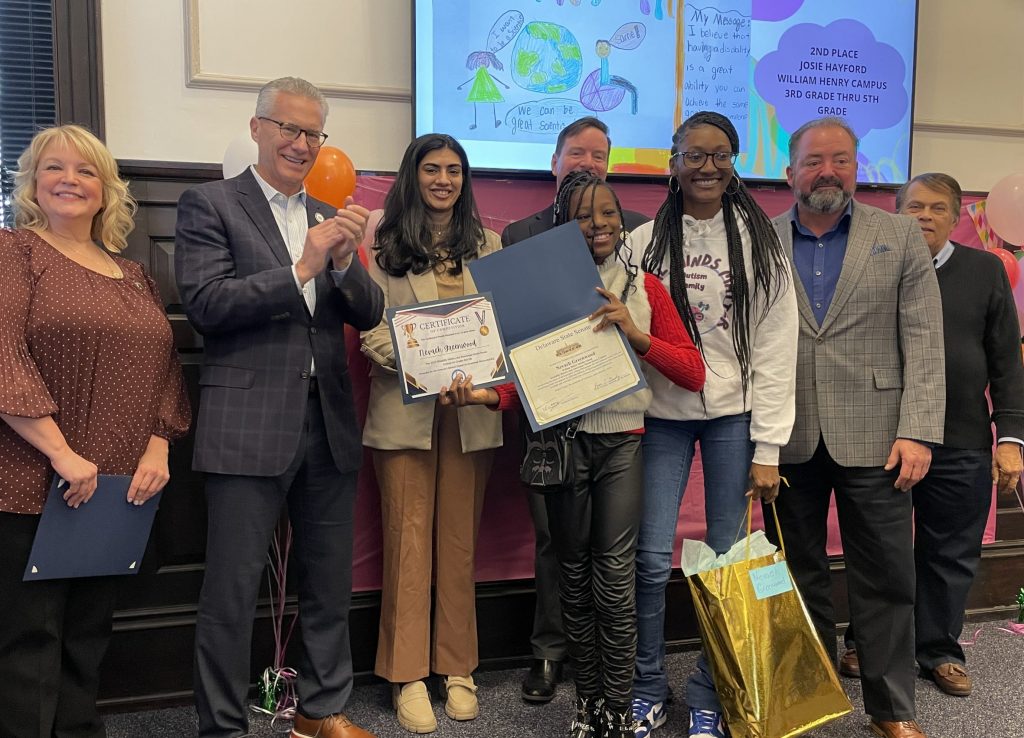 Nevaeh Greenwood, the 1st place winner of the 3rd through 5th grade category, is pictured alongside her mother, GACEC Executive Director, Pam Weir, Representative Yearick, Khazra Fatima, Senator Paradee, Mayor Christiansen and Dr. Erik Warner of William Henry Campus.