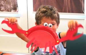 Child showing off crab art project