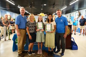 Young winners pose with certificates with adults