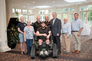 Seven people pose with a man who is parapalegic after he demoed this all-terrain wheelchair July 12 at the Deerfield Clubhouse in White Clay Creek State Park.