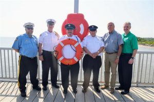 Fire company members and DNREC Secretary showing life ring at Woodland beach