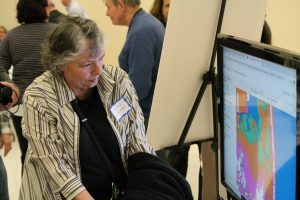 A visitor reviews a computer screen showing climate impacts in Delaware.