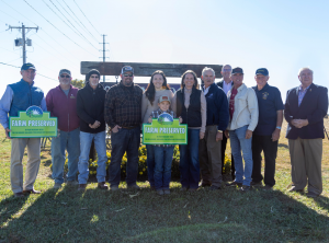 The Cartanza Family is joined by Governor Carney, Secretary Scuse, and legislators for a picture with their new Aglands Preservation farm sign in front of their Shadybrook Farms sign at the end of their farm lane.