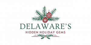 The words Delaware's Hidden Holiday Gems are centered around green holly branches and red ornaments.