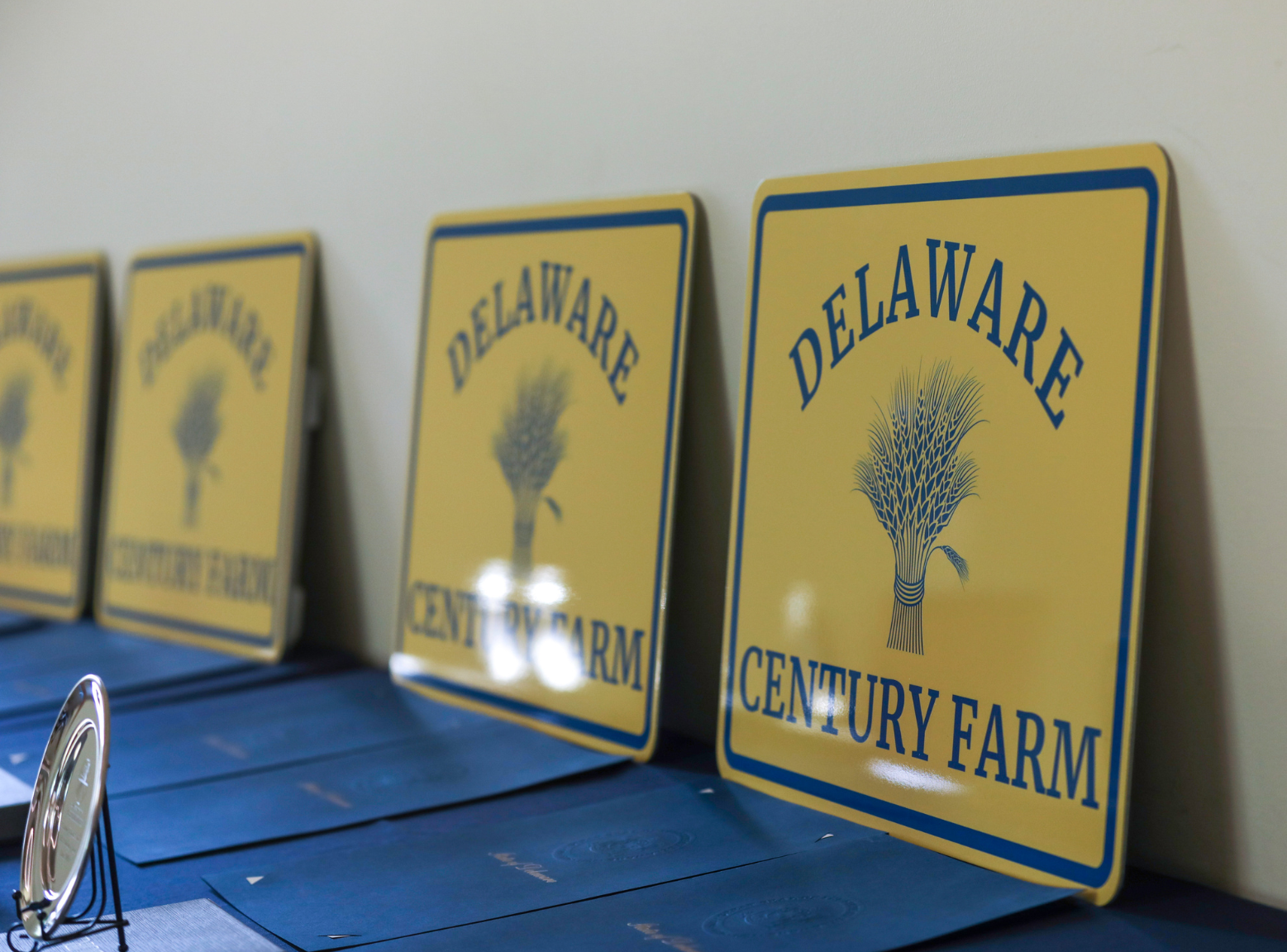 The new Delaware Century Farm signs on display, along with tributes and an engraved pewter plate to be presented to a farm family receiving this designation.