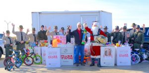 DNRP Officers pose with the Secretary and Santa in front of donated toys.