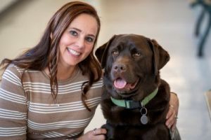 Smyrna Educational Support Professional of the Year Melissa Wilson sits with her therapy dog Rebel.