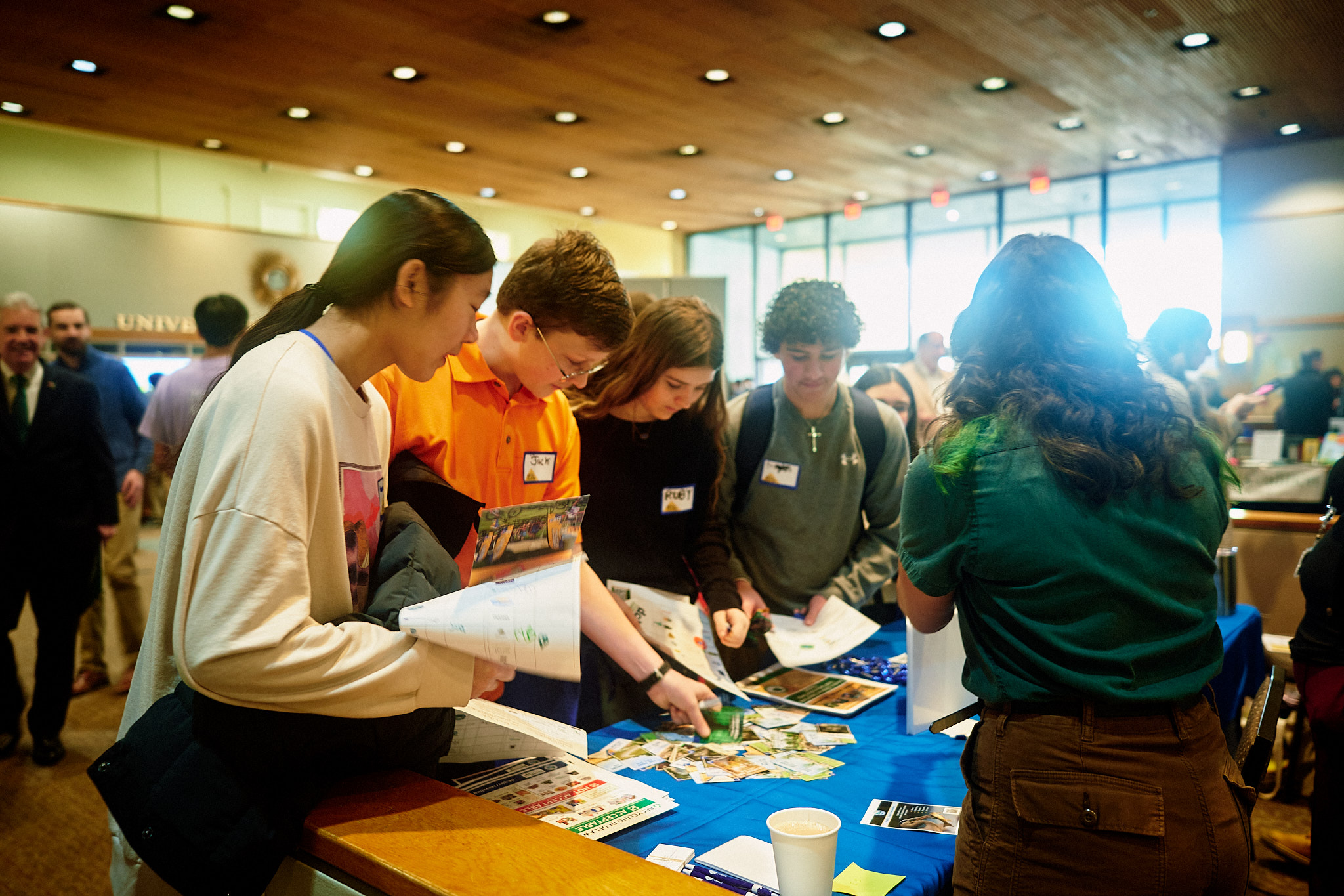 Four high school students gather around a DNREC display table at last year’s Youth Environmental Summit, learning about environmental initiatives and picking up informational materials.