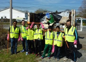 A youth group in safety vests with trash during a cleanup