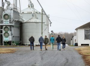 Group of people walking towards grain bins on a farm