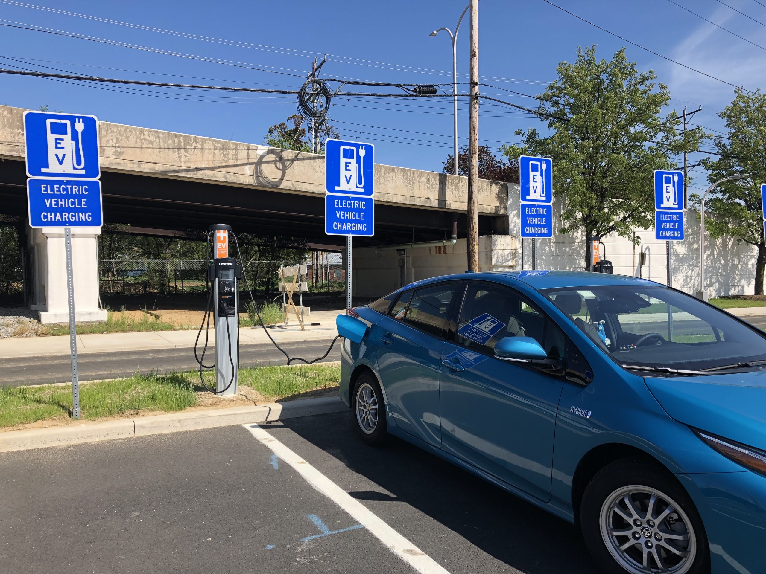An electric vehicle uses a public charging station to recharge.