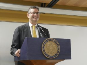 Governor Matt Meyer stands in front of a podium.