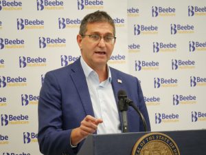 Governor Matt Meyer stands at a podium with a Beebe Healthcare logo background.