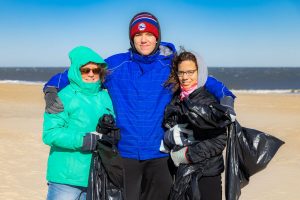 Three volunteers, bundled up against the cold, help clean up Cape Henlopen State Park during the winter months.