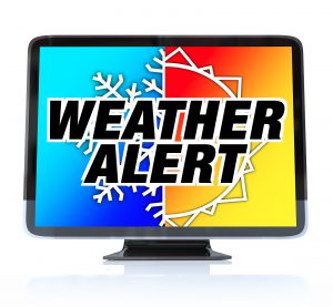 Computer monitor displaying the words ‘Weather Alert’ over a split background with a snowflake on one side and a sun on the other, representing severe weather conditions.