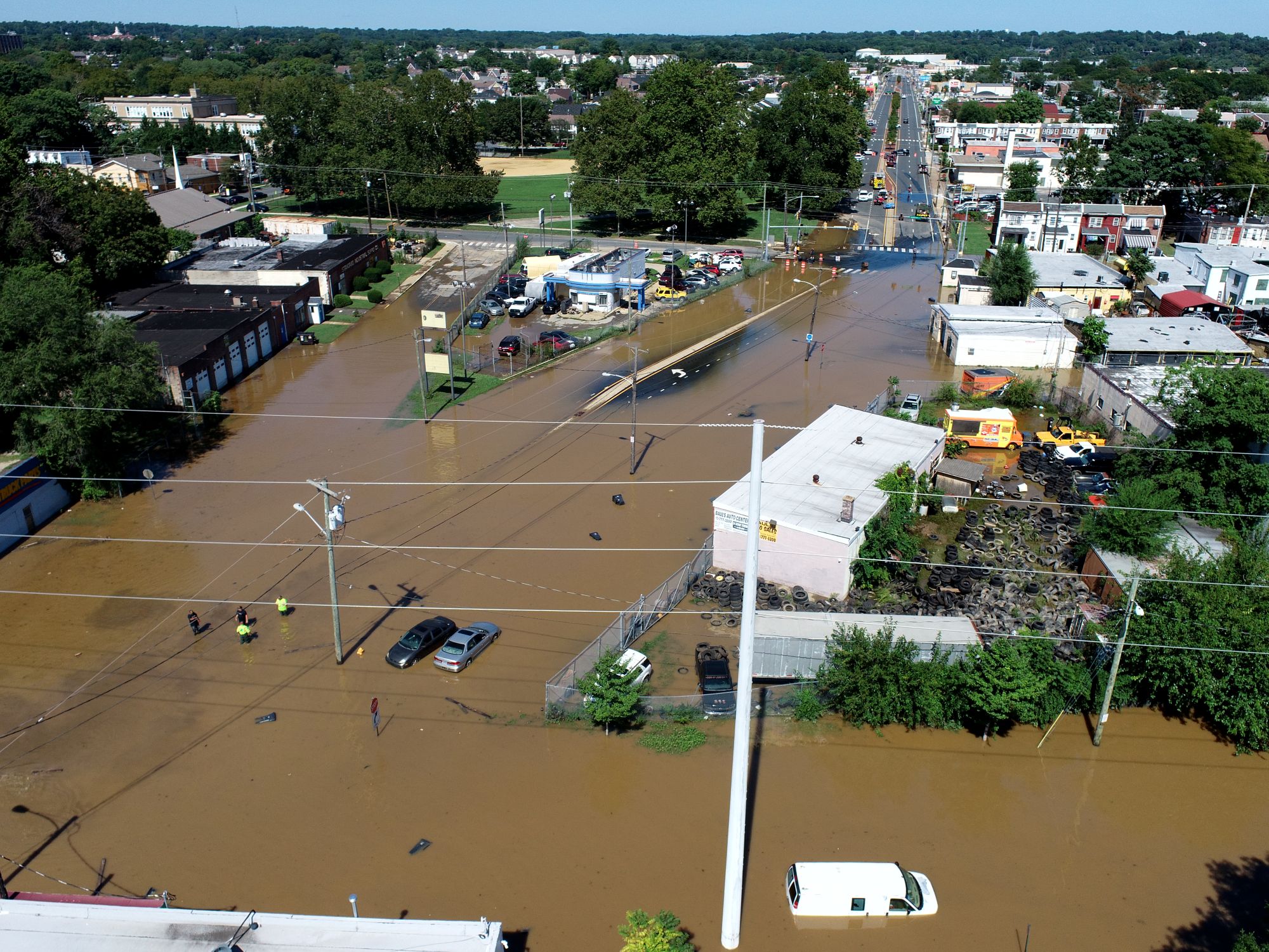 Flooding in the city of Wilmington. Brown water as high as some car doors is shown having spread over roads and businesses in an aerial view.