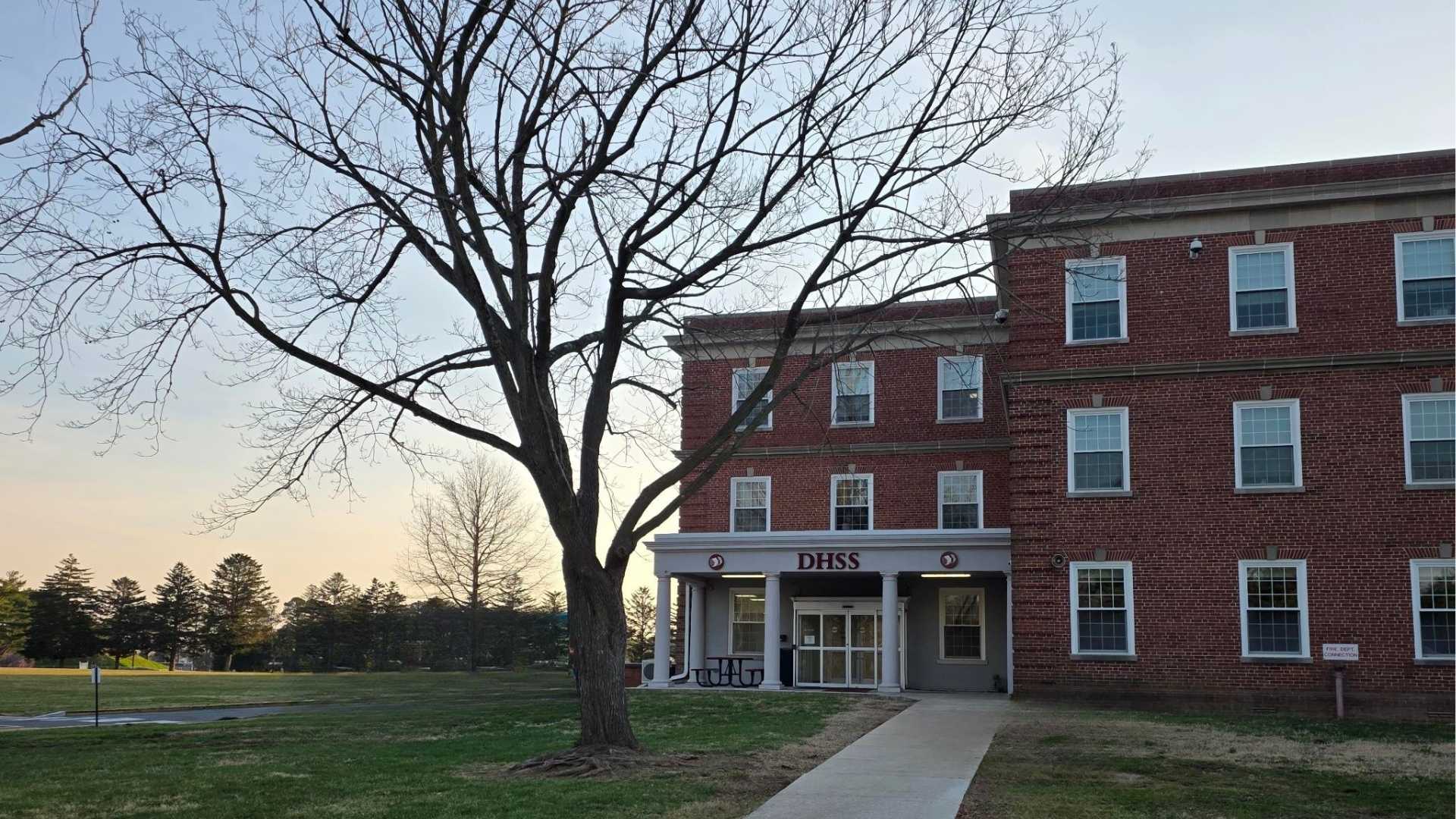 A three story building with the words DHSS over the entrance doors..