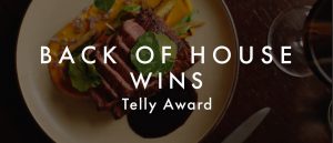 A picture of a dish with text that reads "Back of House Wins Telly Award."