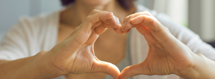 Photo of person making a hand heart.