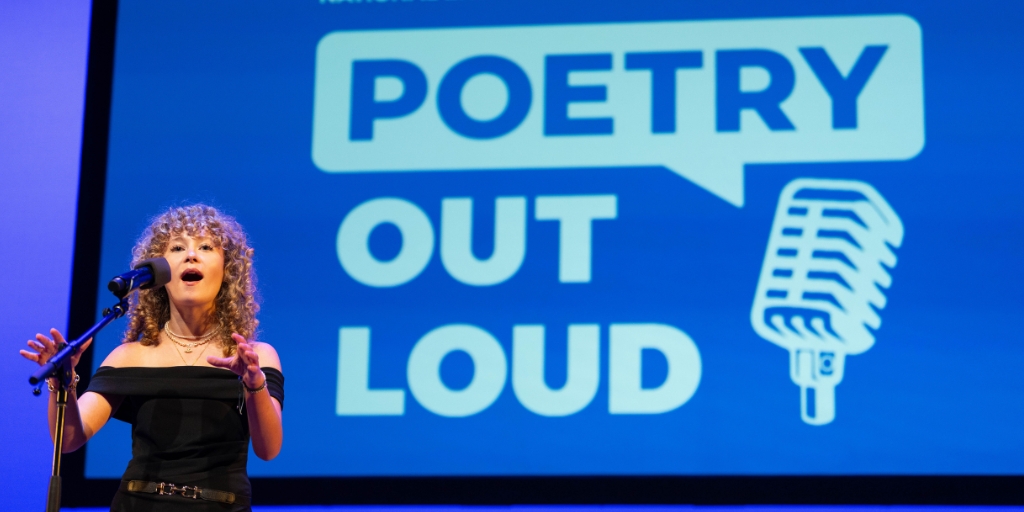 a young student reciting into a microphone with a blue background for poetry out loud